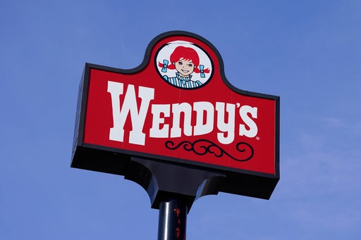 Wendy's restaurant exterior with a car in the drive-thru lane at dusk
